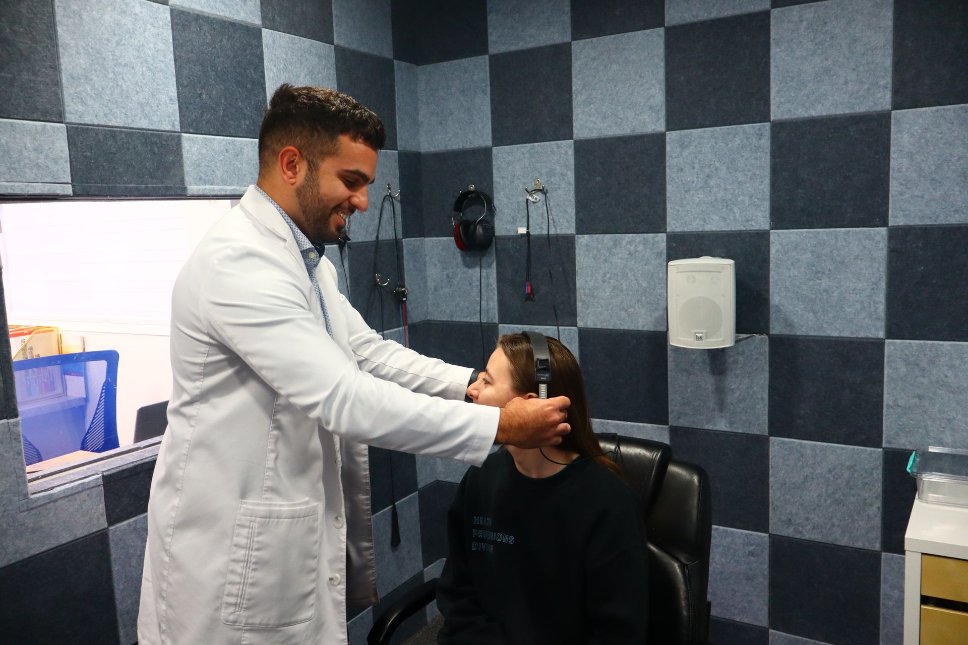 Dr. Farzon Danesh fitting a patient with headphones for a hearing test