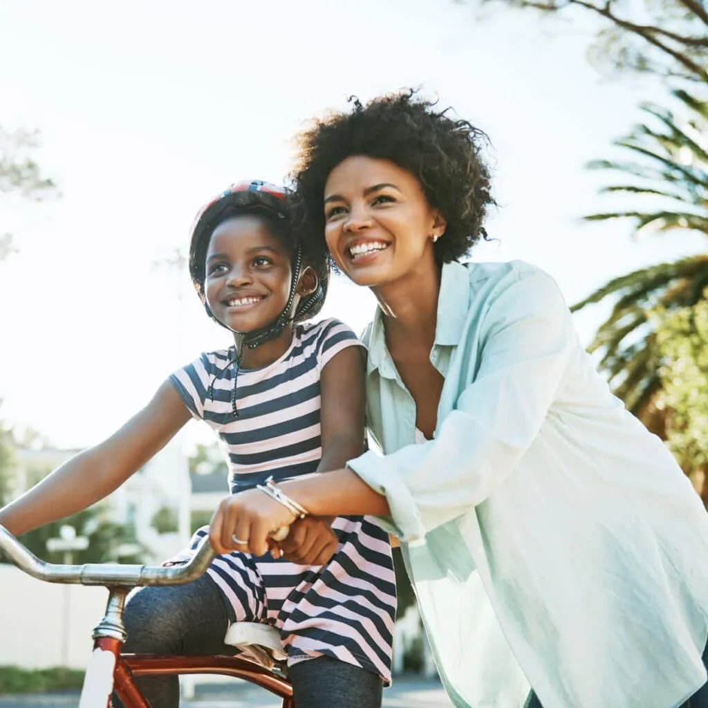 A mother teaching her child how to ride a bike