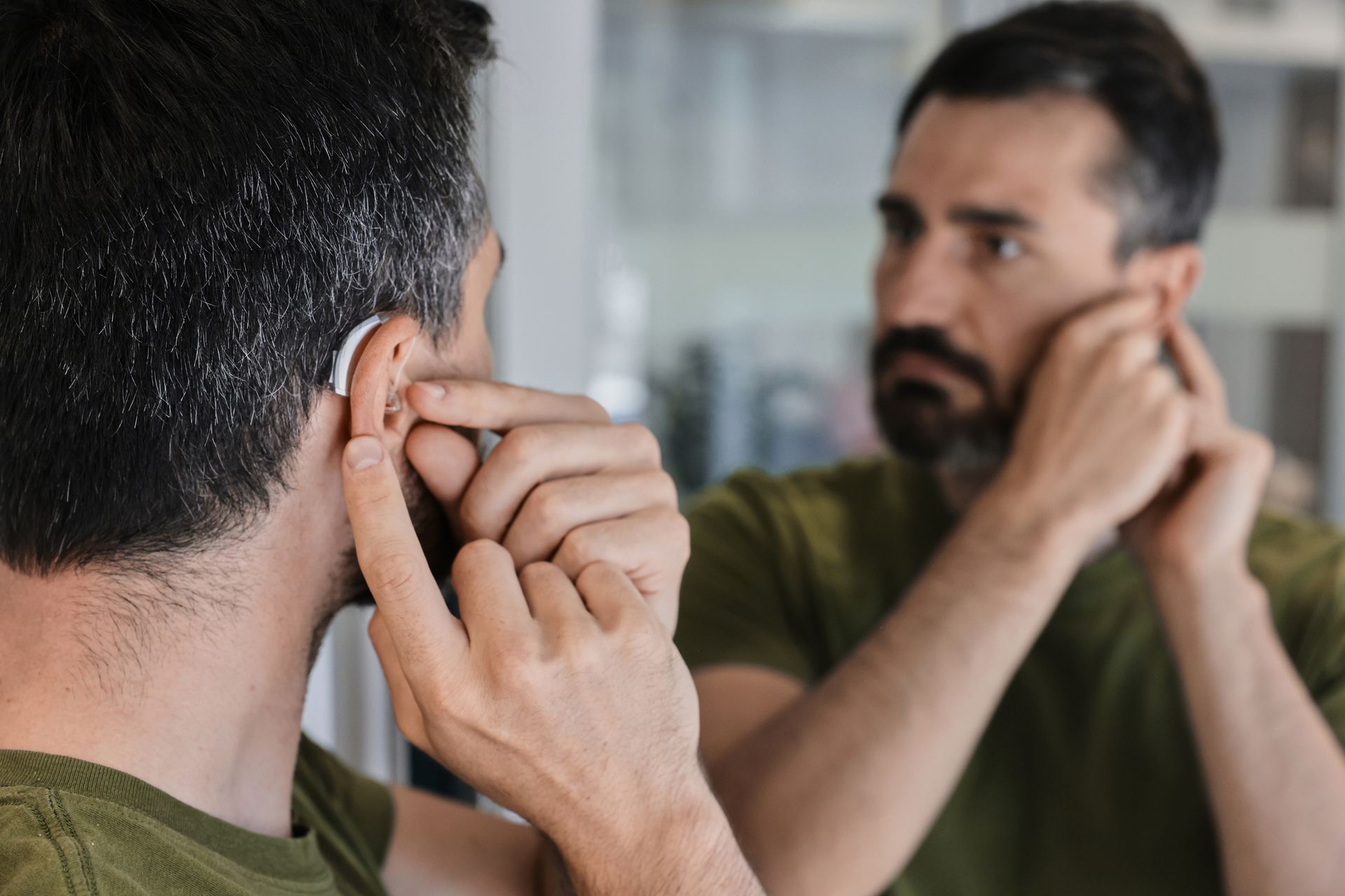 Audiologist fitting a patient with a new hearing aid