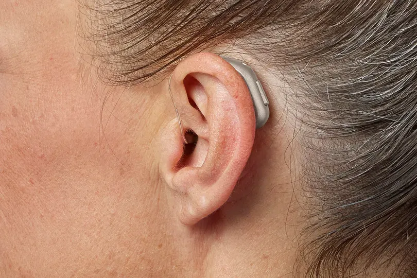 Close-up of a woman wearing an Oticon Intent miniRITE hearing aid