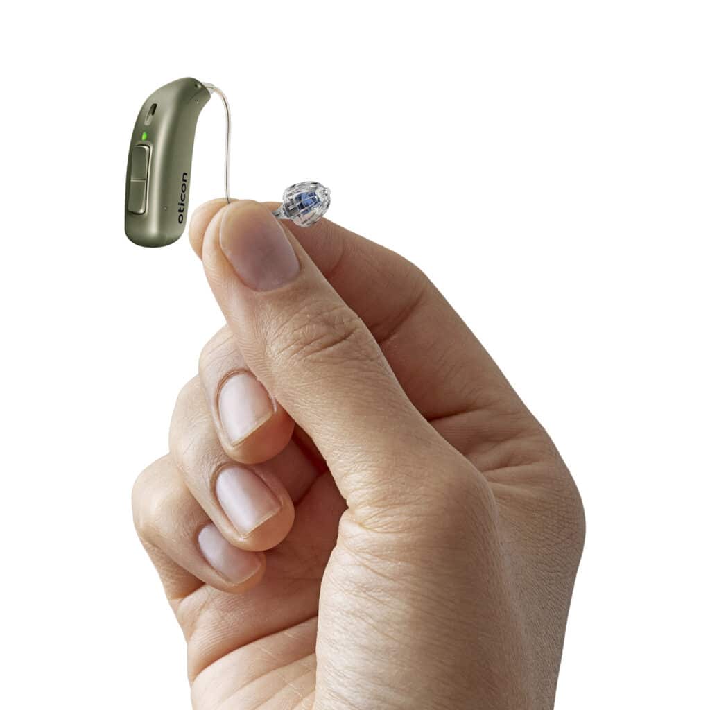 Person holding an Oticon Real hearing aid for display